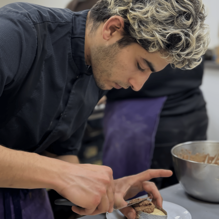 Cuisinier en veste noire dressant une assiette avec précision – CAFA Formations